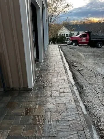 Geometric patterned paver walkway along residential building with finished edges