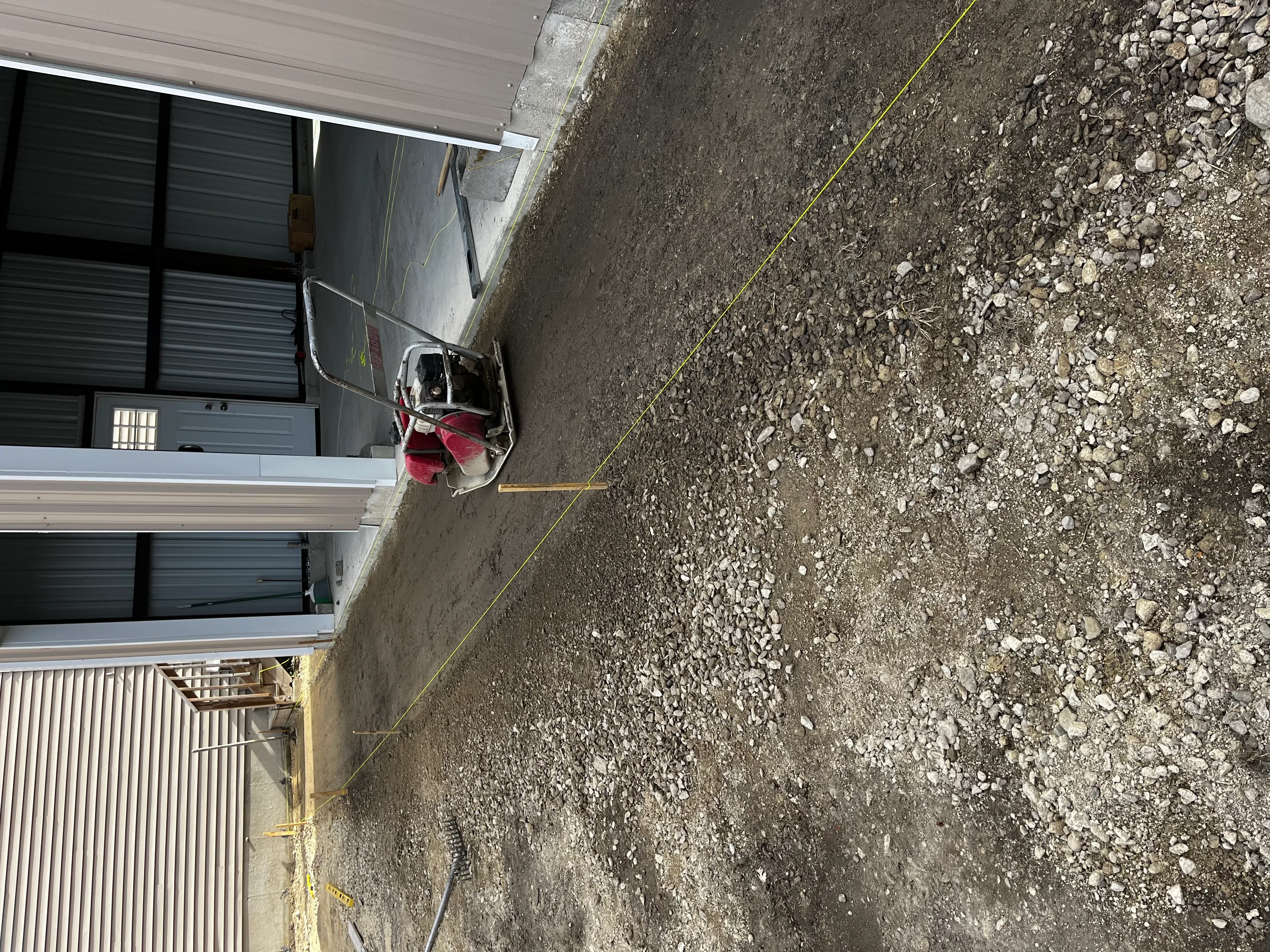 Gravel driveway installation with crushed stone aggregate and measurement lines