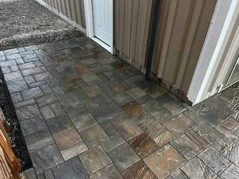 Slate paver patio in herringbone pattern with multi-colored earth-tone tiles