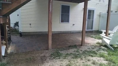 Concrete patio installed under covered structure with wooden posts and beams