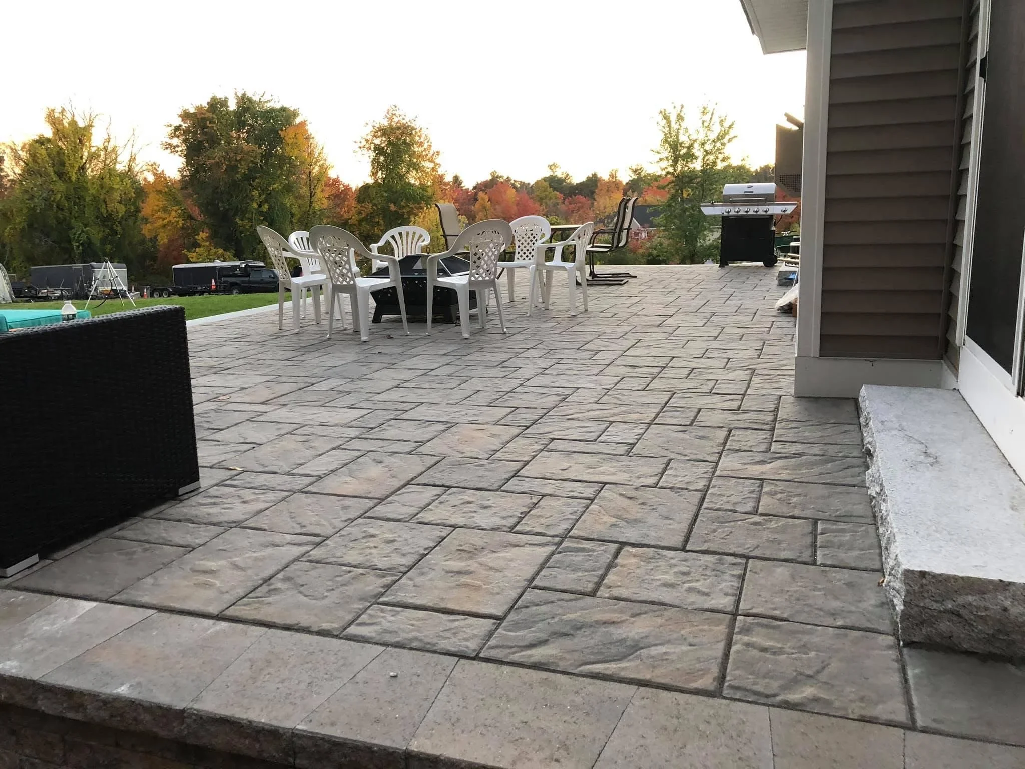 Large natural stone paver patio with running bond pattern and integrated seating area