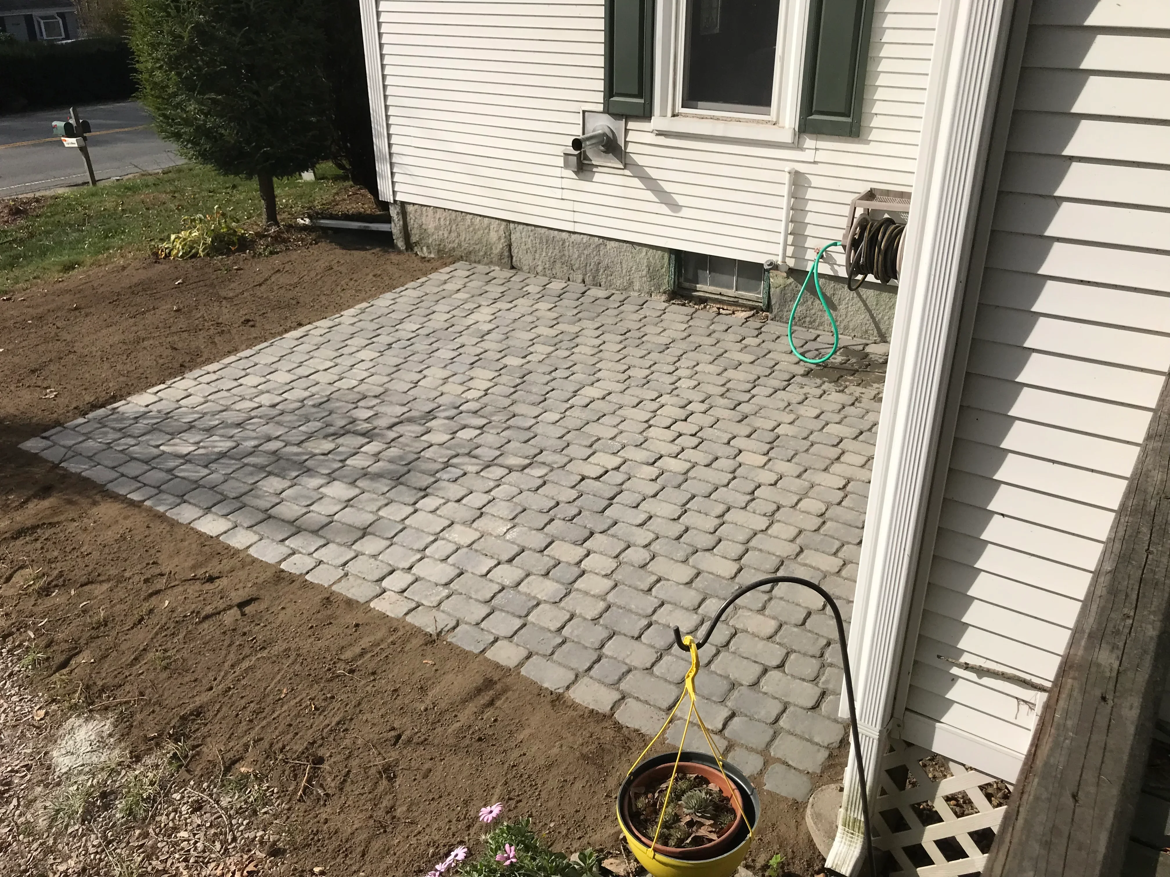 Gray concrete permeable pavers laid in running bond pattern for residential patio installation