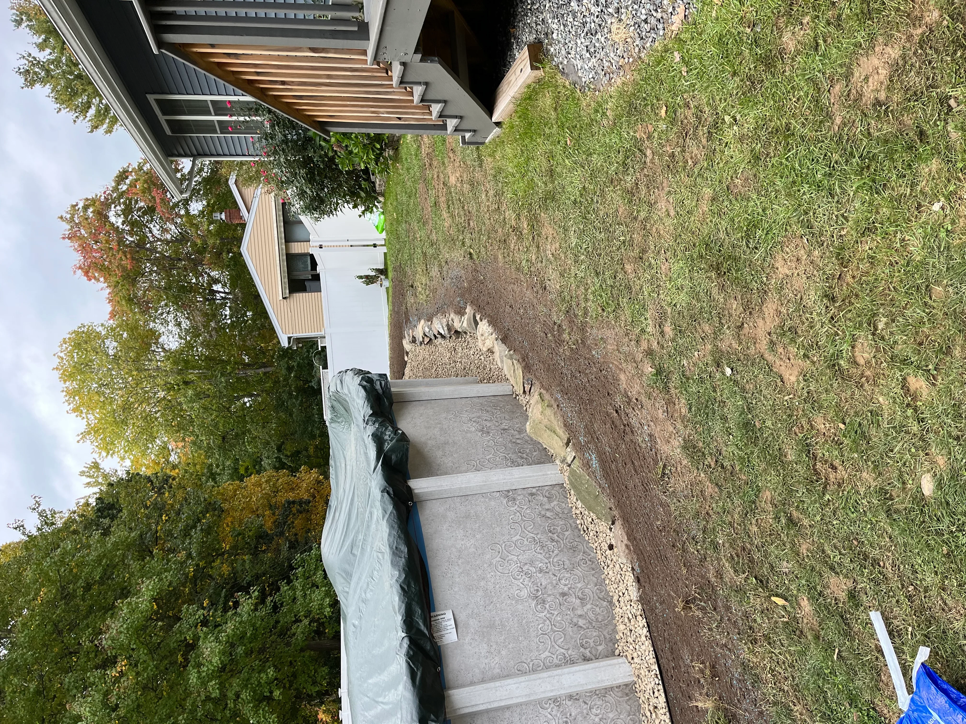 Stamped concrete walkway with gravel base and landscape edging beside residential structure