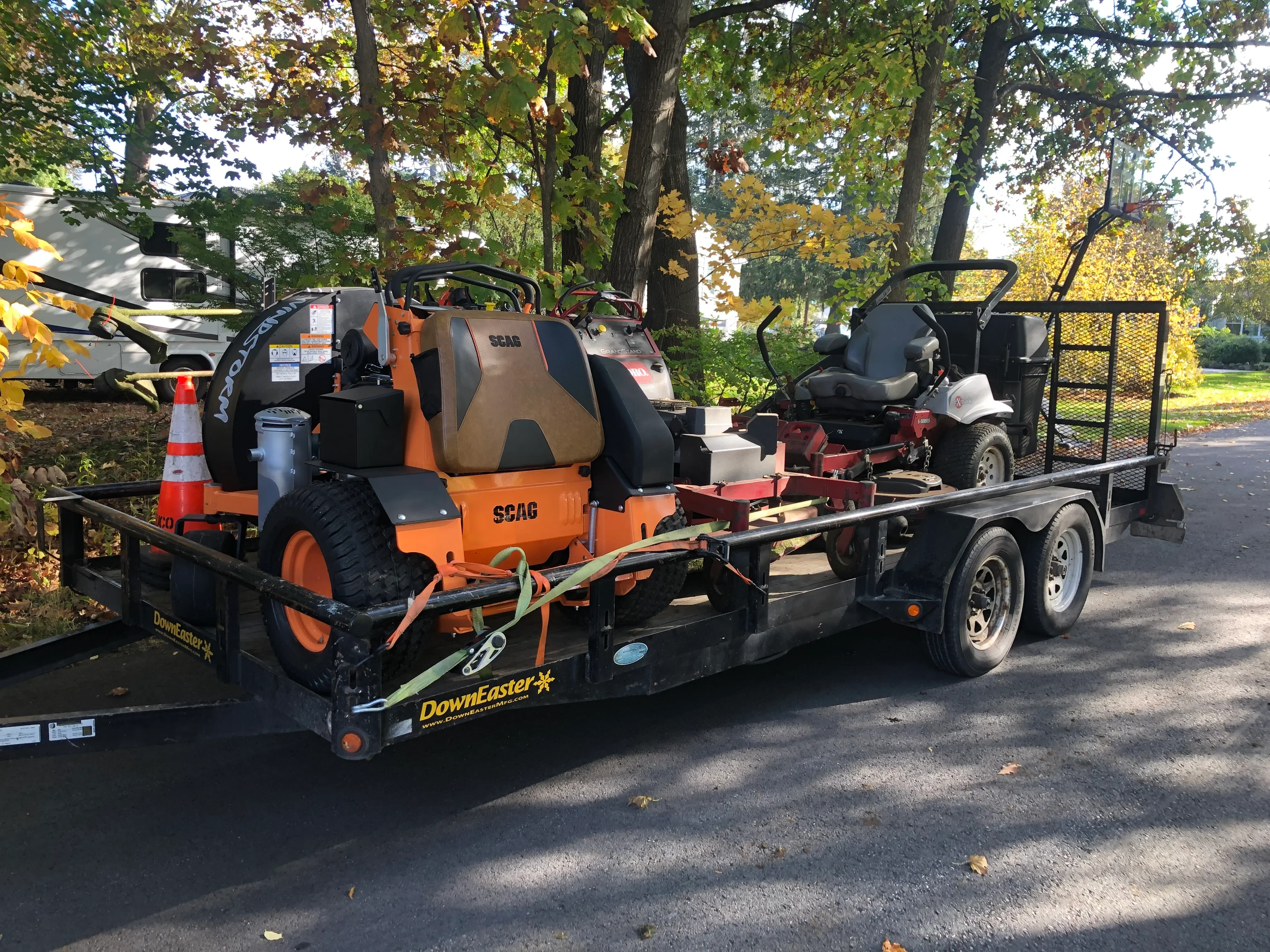 SCAG mower and equipment loaded on Downeaster dual-axle trailer for transport