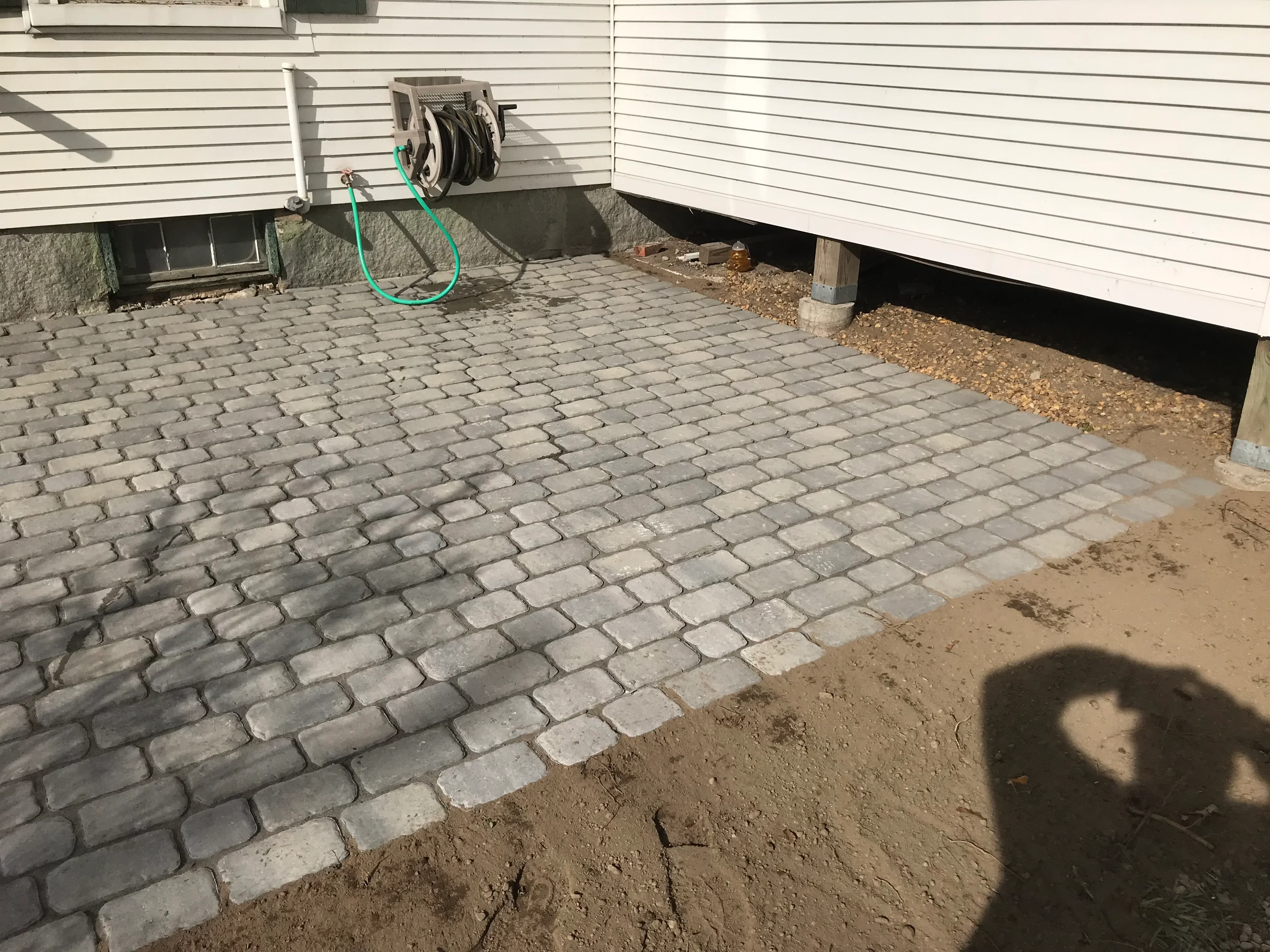 Gray concrete pavers in running bond pattern with black edging and gravel base