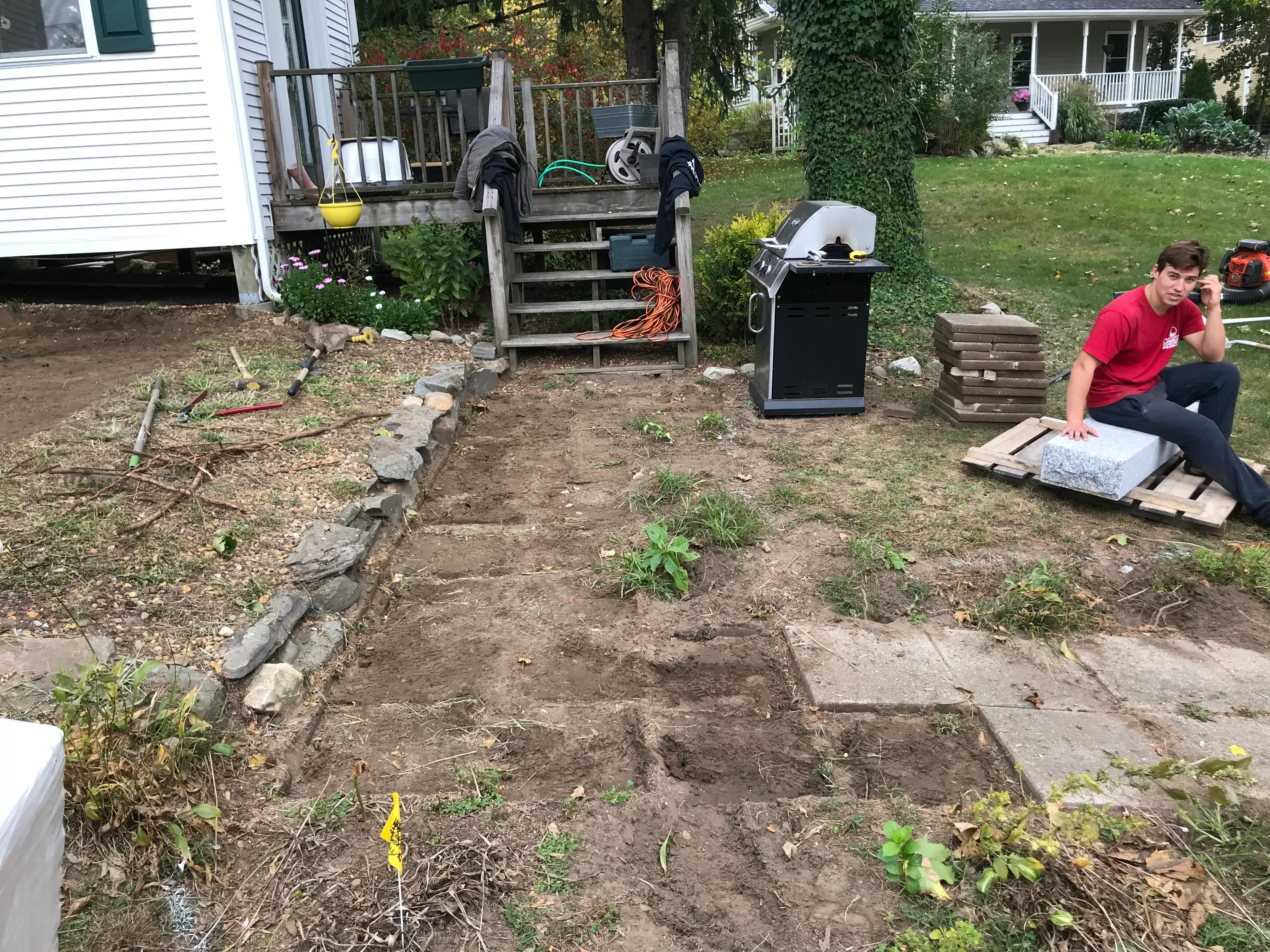 Backyard landscape grading with stone-edged planting beds and prepared soil
