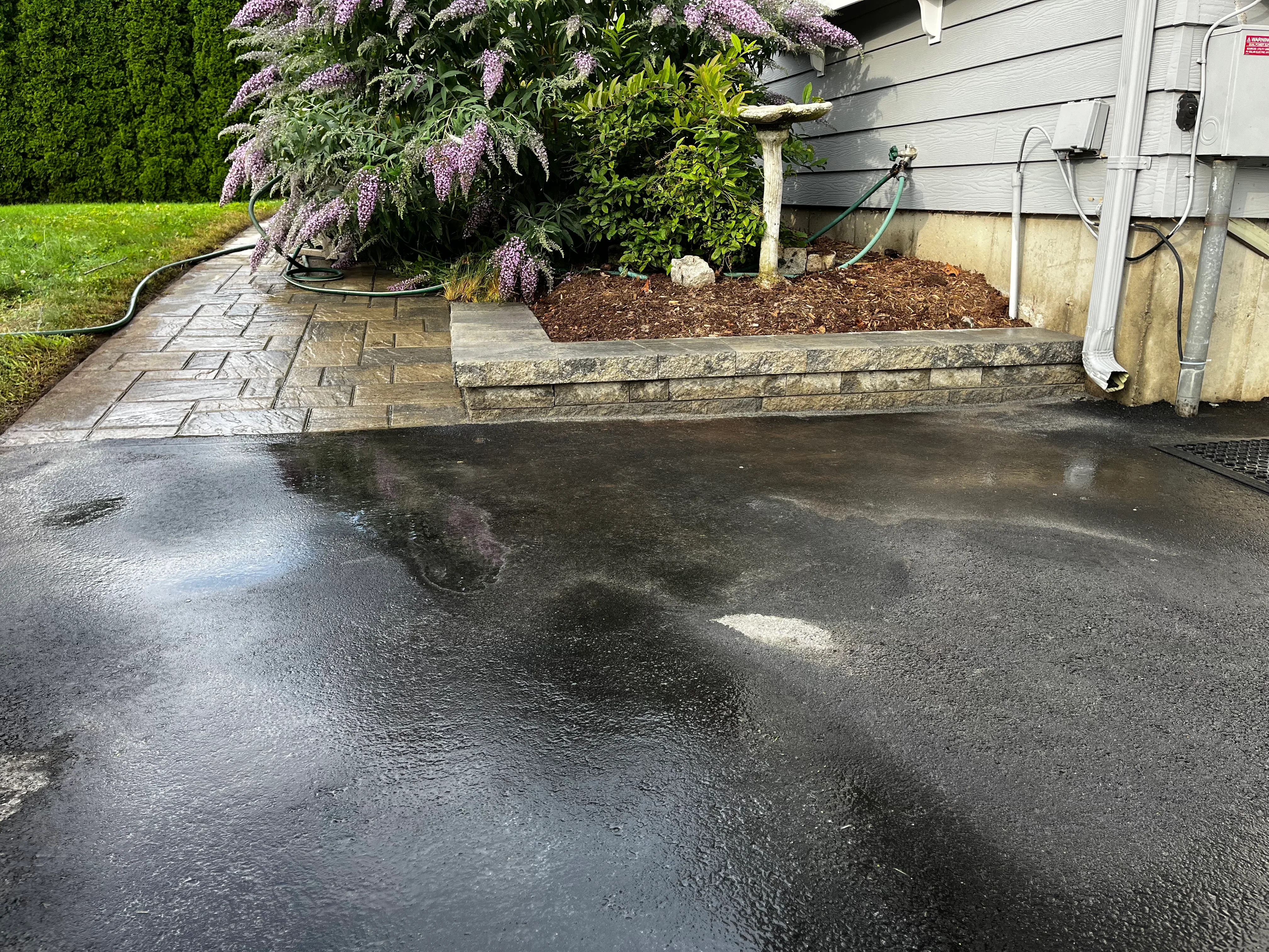 Herringbone paver walkway with stacked stone raised planting bed and mulch landscaping