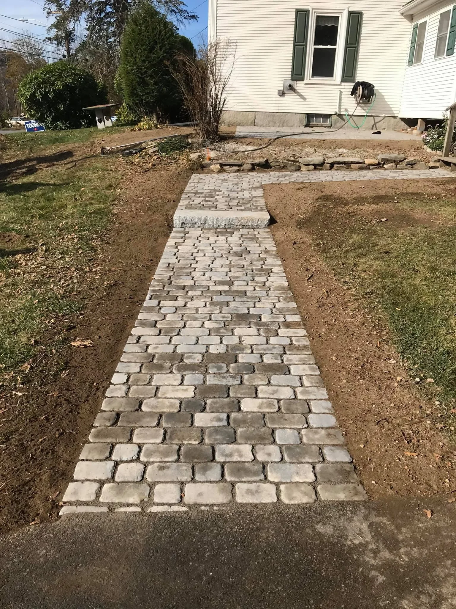 Concrete paver walkway with running bond pattern installed through residential yard