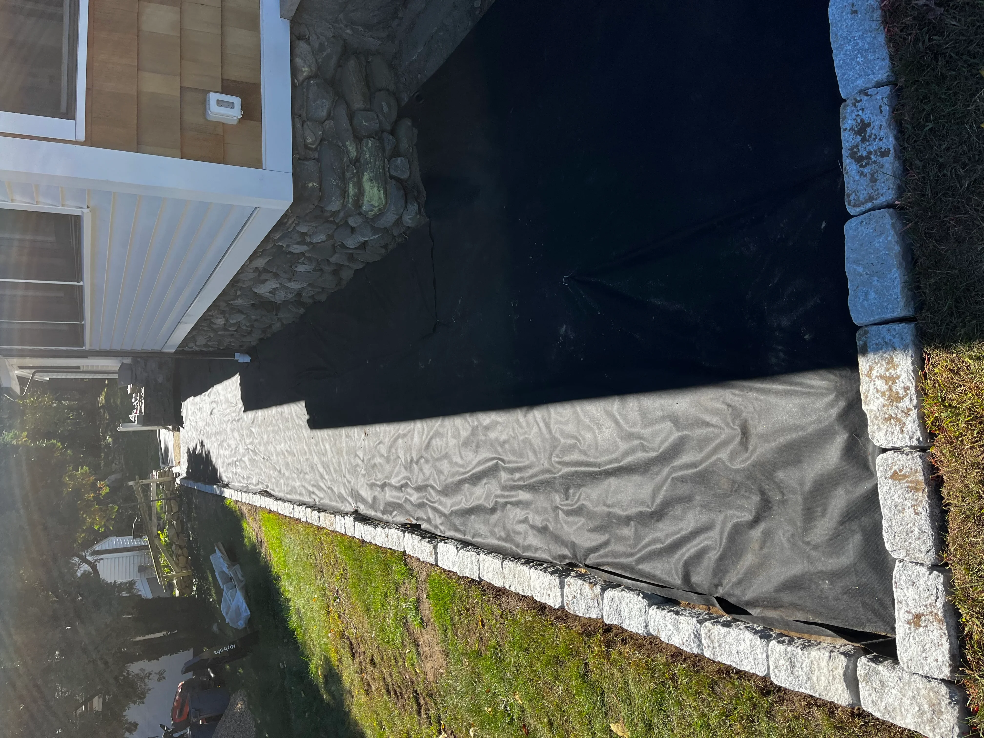 Landscape fabric with white concrete block border edging residential garden bed