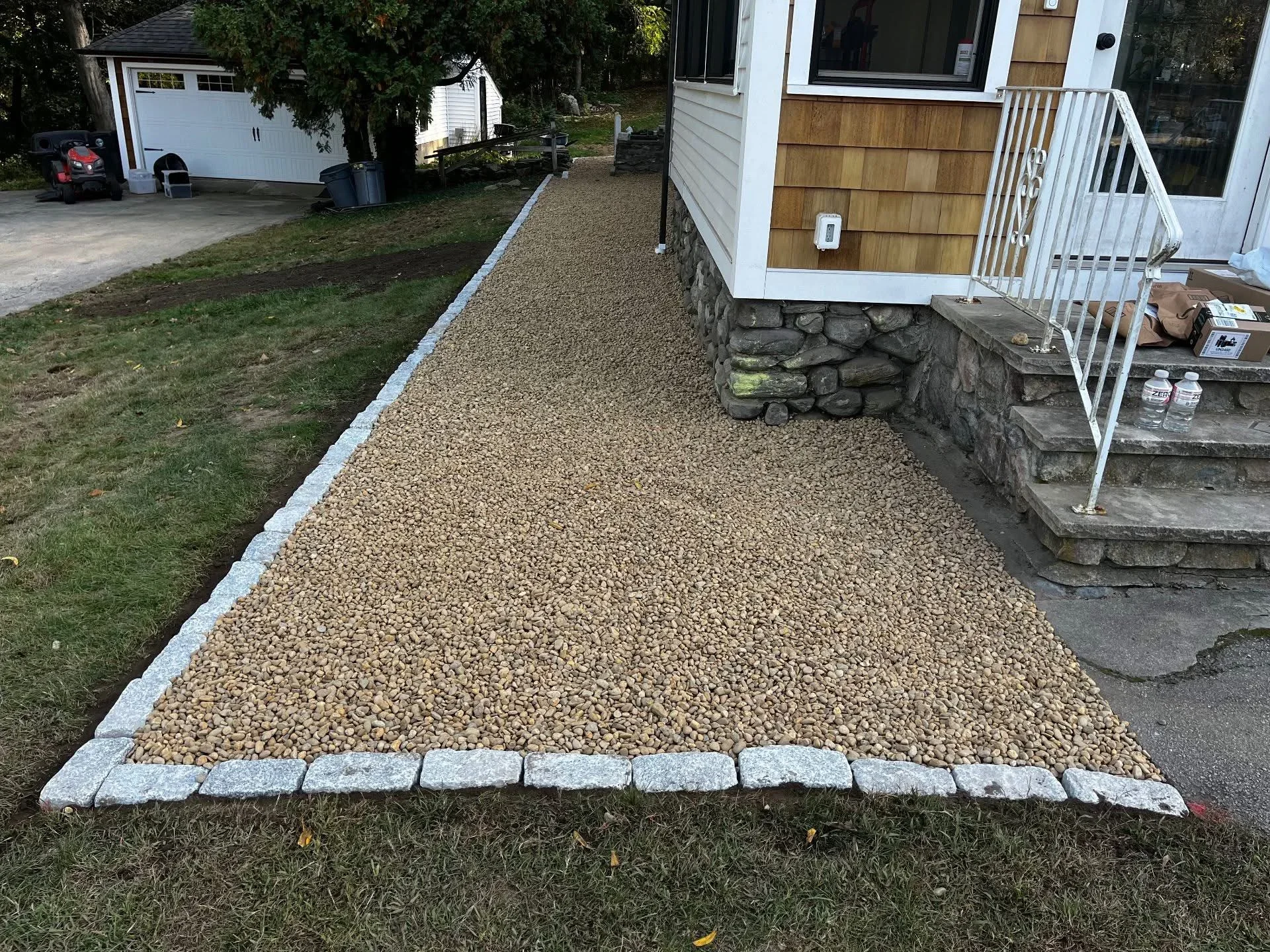 Gravel pathway with granite block edging along residential home foundation