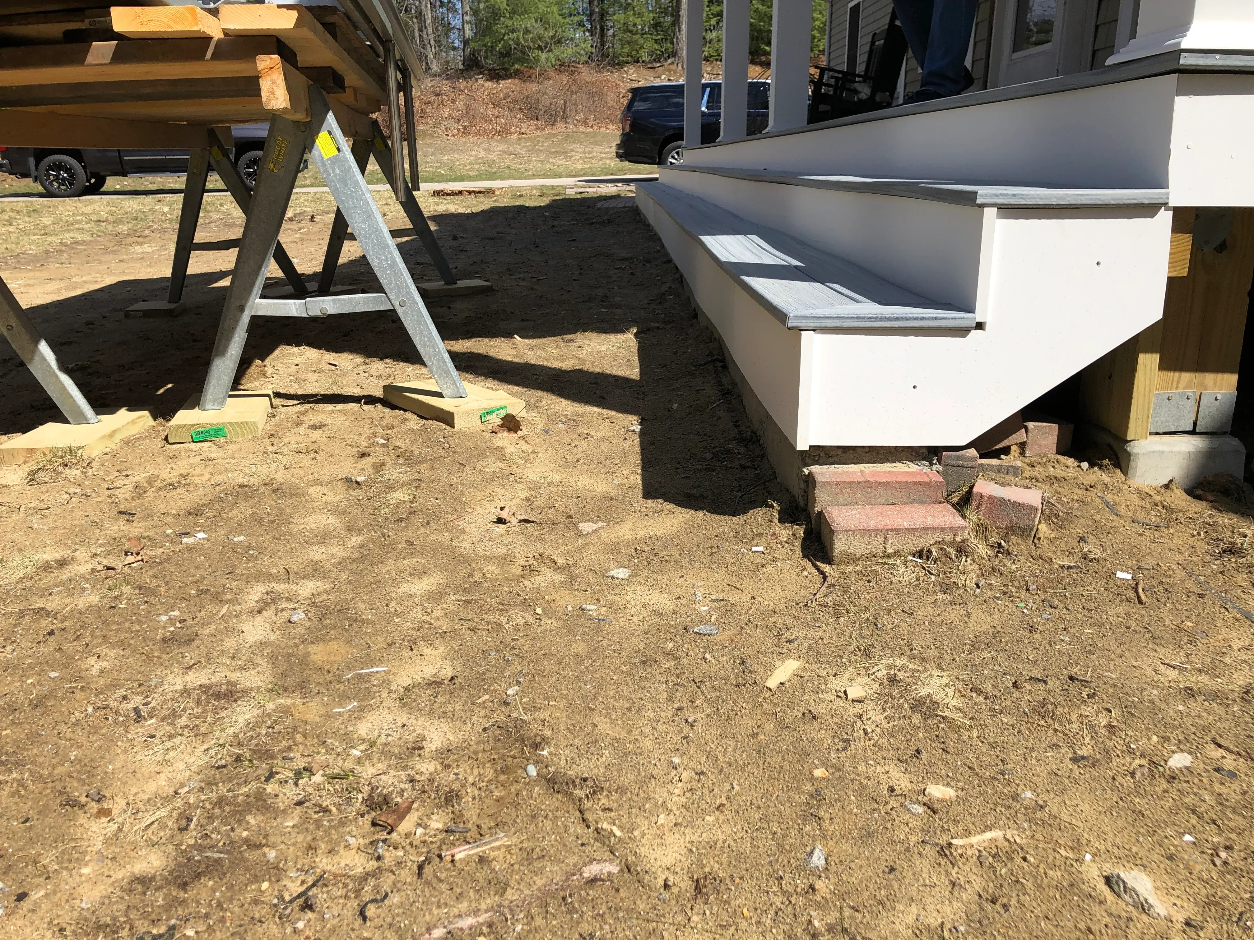 Graded dirt foundation area with brick steps and wooden framing for residential construction