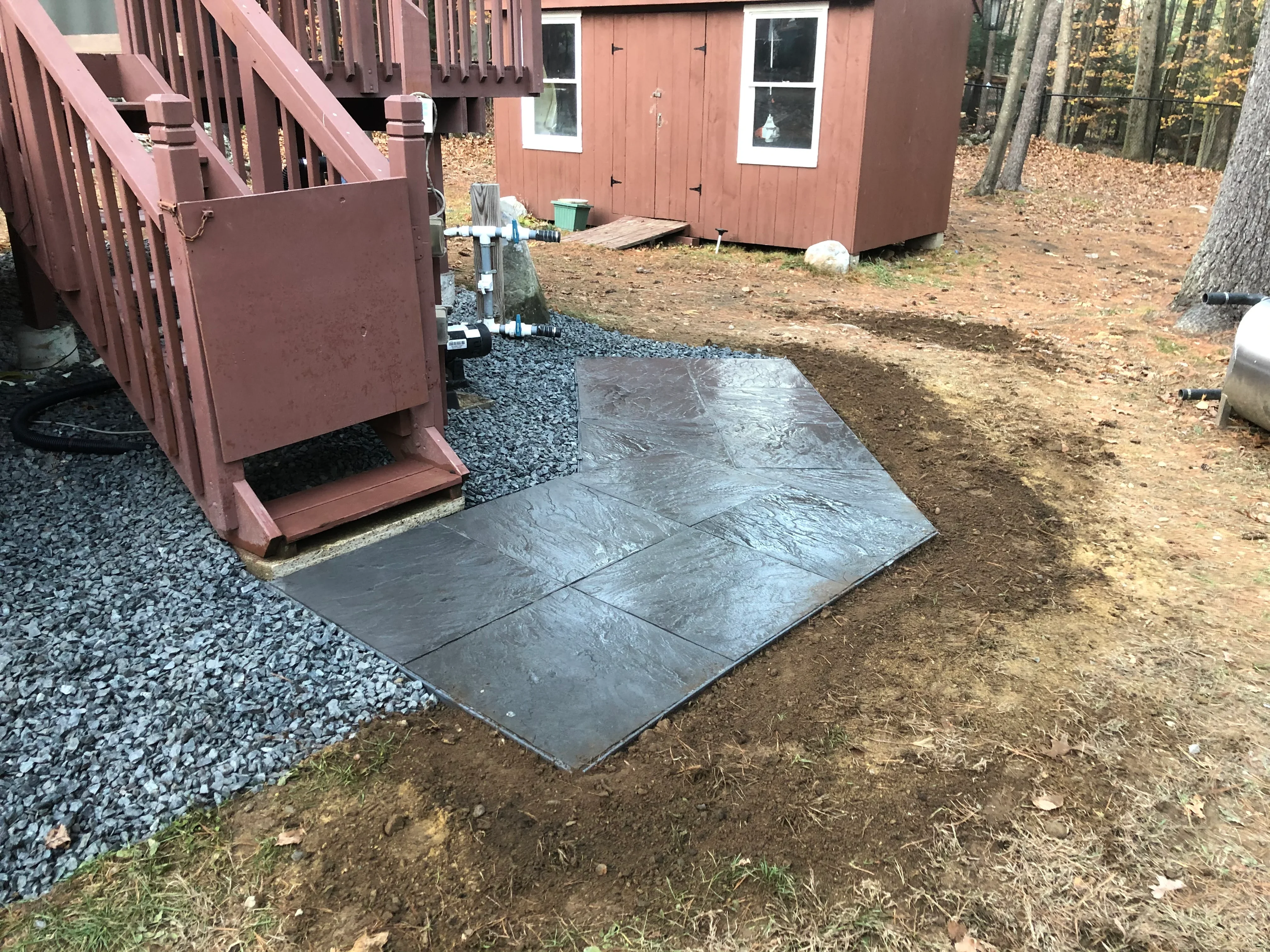 Slate tile walkway with gravel base and crushed stone pad near cabin entrance