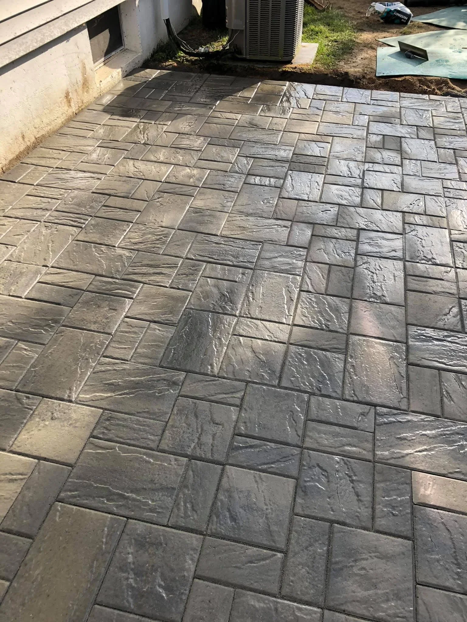 Stamped concrete patio with slate texture pattern and wood-grain finish in gray tones