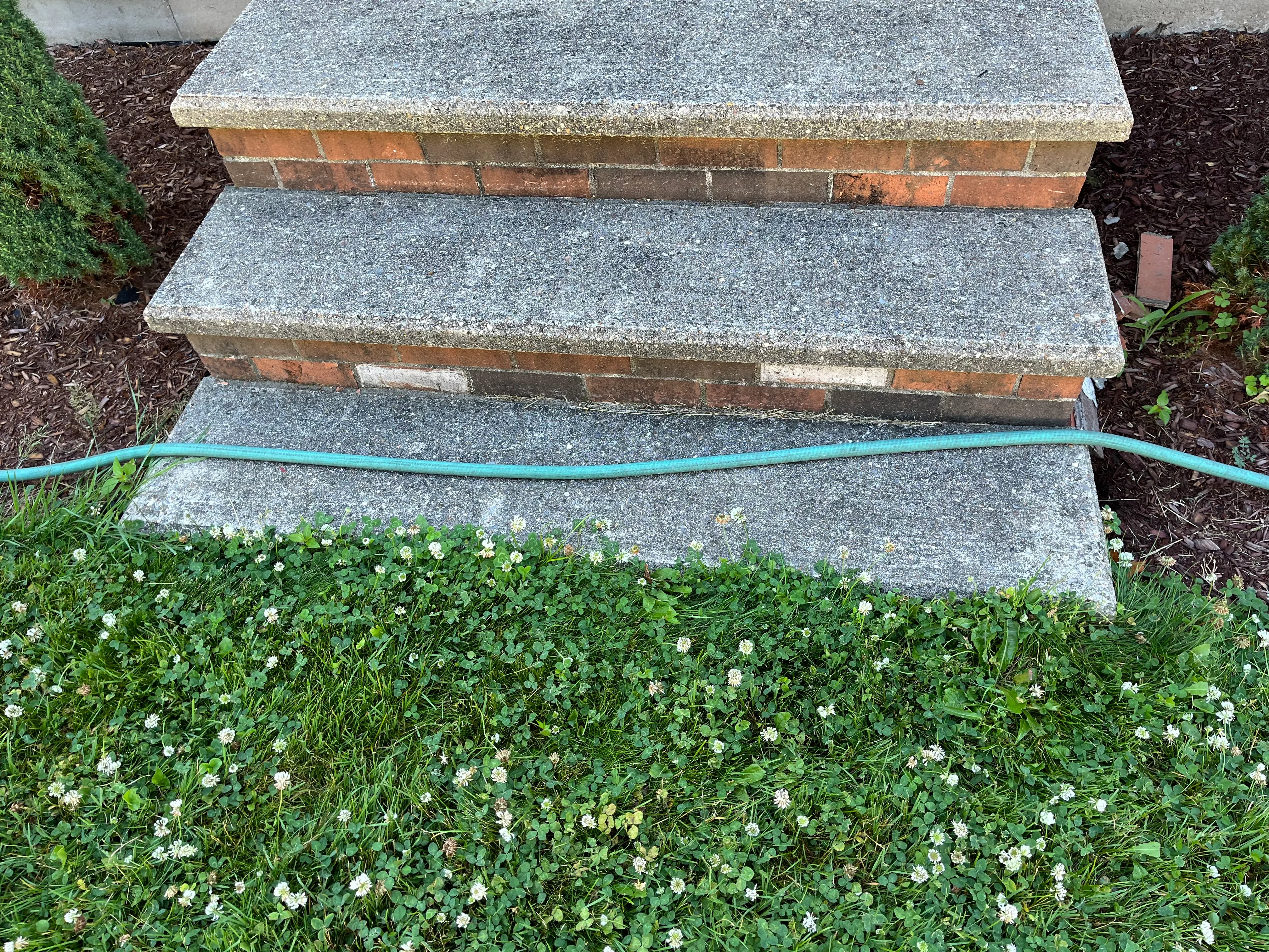 Stacked brick planter beds with stone caps and landscape edging installation